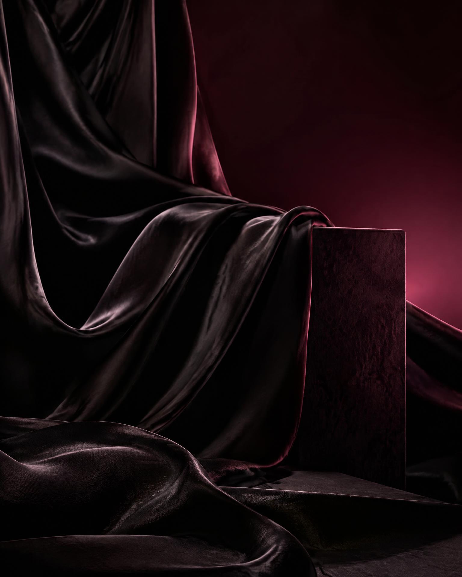 Placeholder campaign image: dark silk drapery lit in deep pink